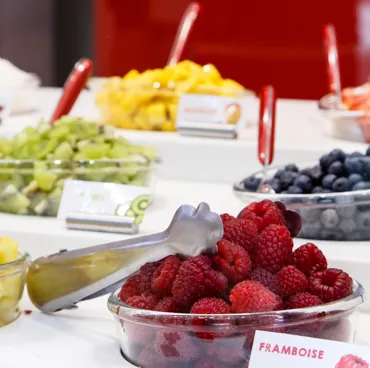 Bar à toppings avec framboises, myrtilles et kiwi